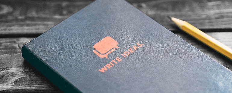 Notebook with “Write Ideas” text and pencil on wooden surface