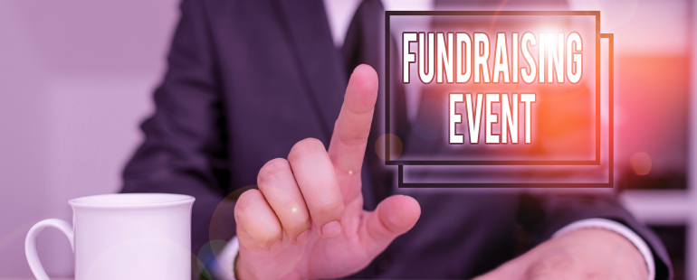 Businessperson pointing toward a digital screen displaying the words "Fundraising Event"