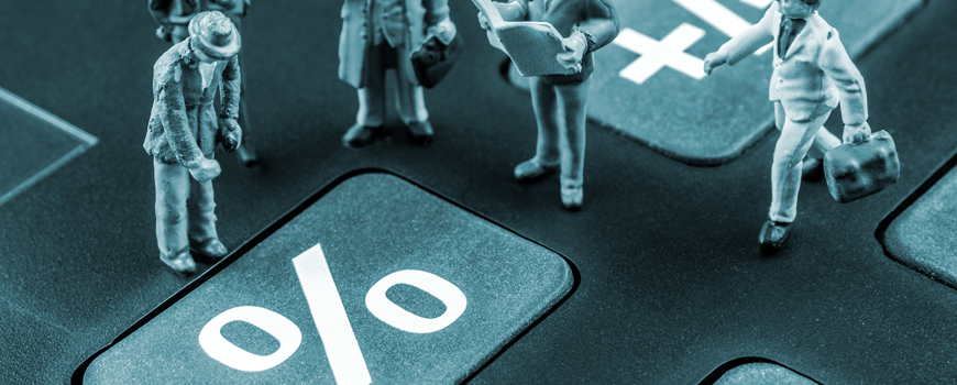 miniature business figures standing on a calculator with a large percent symbol key