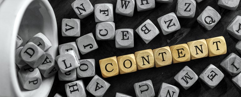 Wooden letter blocks spelling the word “CONTENT” in gold among scattered gray blocks