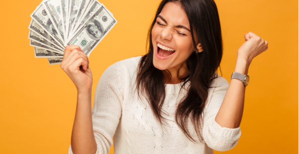 a woma cheering holding a wad of cash