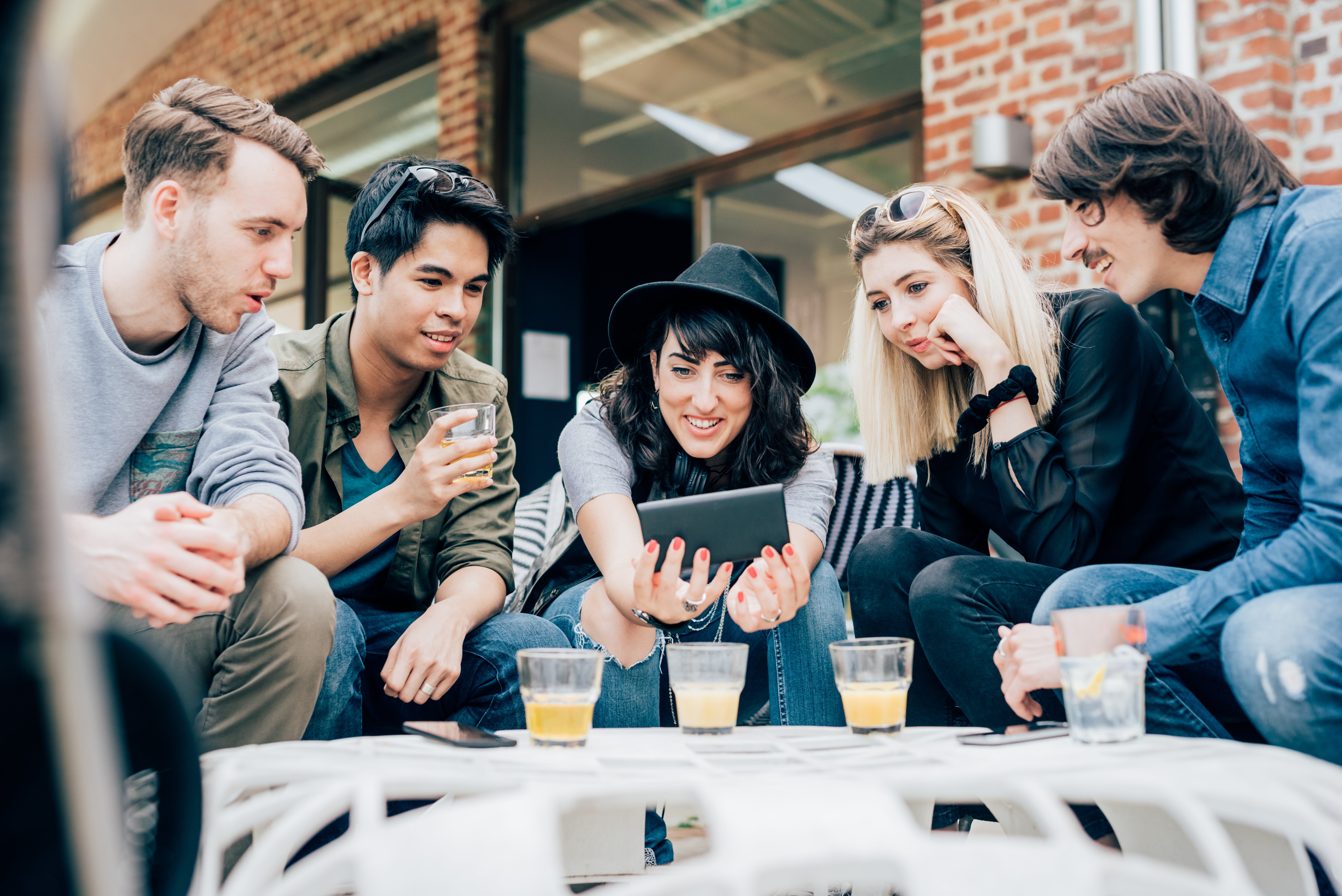 a group of young adults gathered around a tablet
