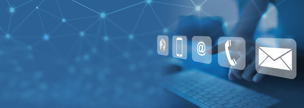 Digital icons for communication methods including phone, email, and chat floating over a keyboard with blue network background