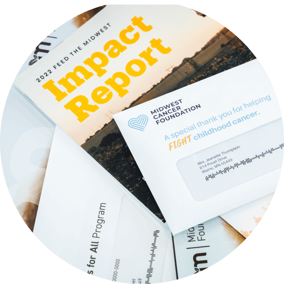 Stack of impact reports and donation appeal letters from the Midwest Cancer Foundation with a focus on childhood cancer support initiatives.
