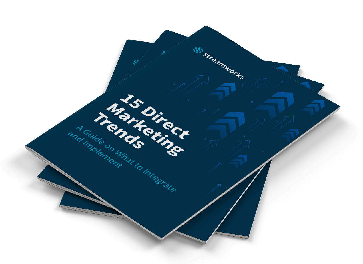 Stack of '15 Direct Marketing Trends' guides with blue covers featuring arrows and text, indicating future strategies and implementations.